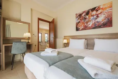 a hotel room with two beds and a mirror at Ar & Al Luxury Villa in Galatás