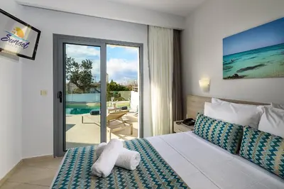 a bedroom with a bed and a view of the ocean at Sunset Elafonisi Apartments in Livadia