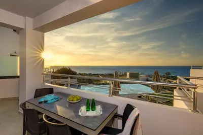 a balcony with a table and a view of the ocean at Sunset Elafonisi Apartments in Livadia