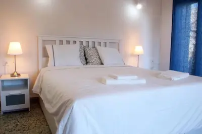 a white bed with two towels on top of it at Daphne's house Families Only in Chania Town