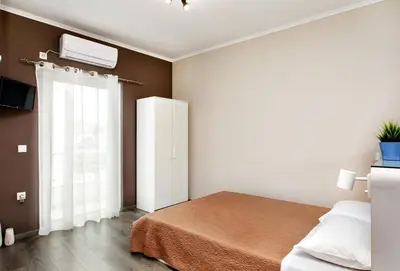 a bedroom with a bed and a window at Maria's modern studio 5min from beach in Souda