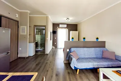 a living room with a couch and a kitchen at Maria's modern studio 5min from beach in Souda
