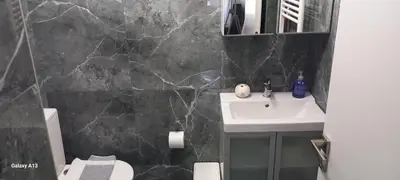a bathroom with a sink and a black marble wall at GIANNIS in Galatás