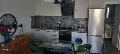 a kitchen with a stainless steel refrigerator and a table at GIANNIS in Galatás