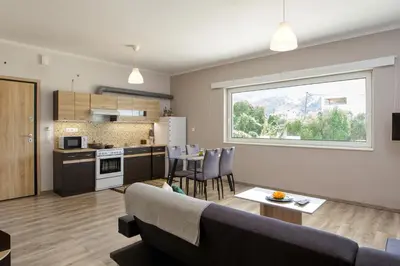 a living room and kitchen with a couch and a table at Stellina's new studio 5min from beach in Souda