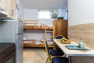 a small kitchen with a table and chairs and a bunk bed at Aqua Marine in Falasarna