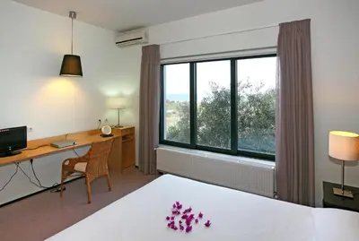 a hotel room with a bed and a desk and a window at Villa Bamboo in Maleme