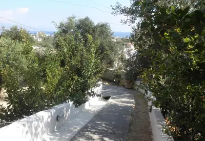 a garden with trees and a white fence at Villa Bamboo in Maleme