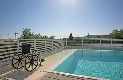 a chair sits next to a swimming pool at Villa Bamboo in Maleme