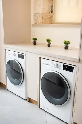 a laundry room with two washing machines and a counter at Amaré Chania Luxury Residence in Stérnai