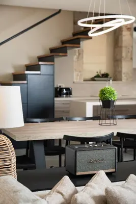 a dining room with a table and a kitchen at Amaré Chania Luxury Residence in Stérnai