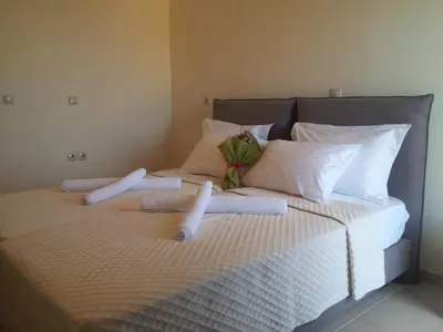 a bed with white sheets and pillows on it at Crete View in Marathi