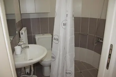 a bathroom with a sink and a toilet and a shower curtain at Crete View in Marathi