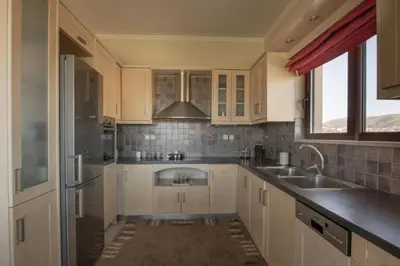 a kitchen with white cabinets and a sink at Terpsis House in Kissamos