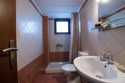 a bathroom with a sink and a toilet and a shower at Terpsis House in Kissamos