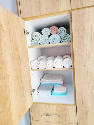 a cabinet with towels and books in it at Marlen House Chania in Chania Town