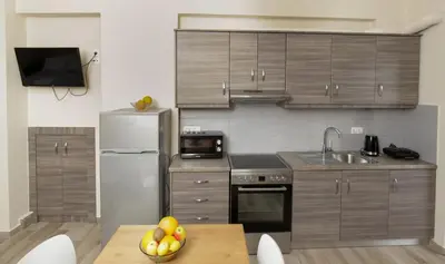 a kitchen with stainless steel appliances and a wooden table at Captain Nick in Chania Town