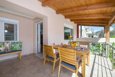 a dining room with a wooden table and chairs at Manolia Dream Apartment 30m to the beach in Agia Marina Nea Kydonias
