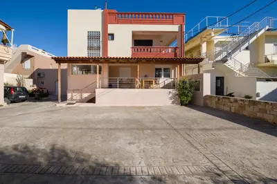 a house with a parking lot in front of it at Manolia Dream Apartment 30m to the beach in Agia Marina Nea Kydonias