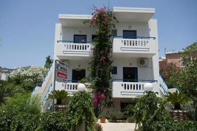 a white building with flowers on the side of it at Anthea Apartments in Palaiochóra