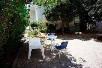 a table and two chairs sitting next to a building at Anthea Apartments in Palaiochóra