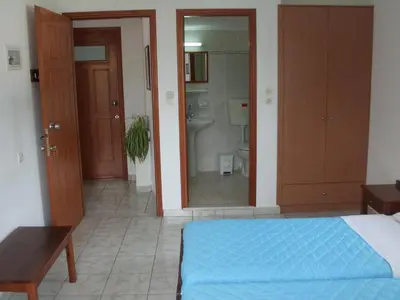 a bedroom with a bed and a bathroom with a toilet at Anthea Apartments in Palaiochóra