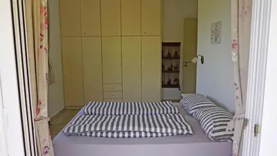 a bed in a room with two pillows on it at Kukuwaia in Almirida