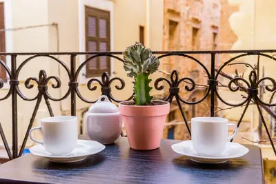 two cups and saucers on a table with a plant at Alegria Pension in Chania Town