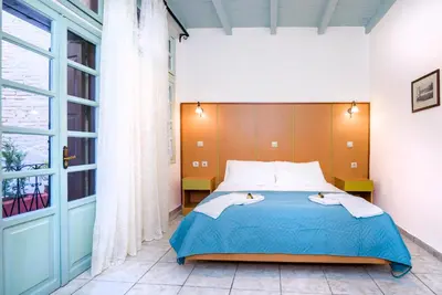 a bedroom with a bed and a large window at Alegria Pension in Chania Town