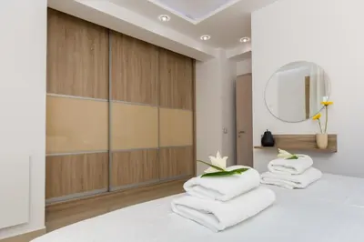 a bedroom with white towels on a bed with a mirror at Larimar Luxury Sea View Villa in Kissamos