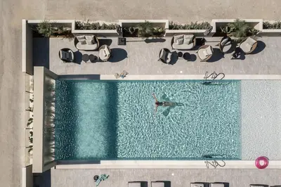 an overhead view of a pool with a person swimming at Mossa Well Being Hotel - Heated pool and Wellness Spa in Kato Daratso
