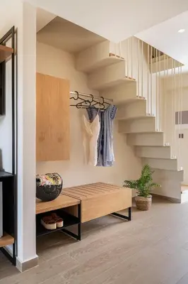 a living room with a wooden bench and stairs at Mossa Well Being Hotel - Heated pool and Wellness Spa in Kato Daratso