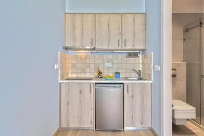 a small kitchen with wooden cabinets and a sink at Celestine Suites in Kolymvari