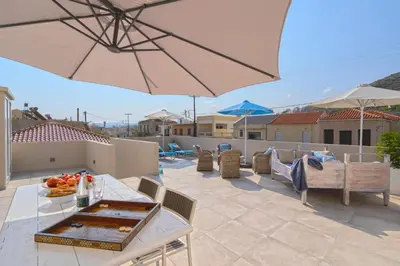 a patio with a table and an umbrella at Celestine Suites in Kolymvari