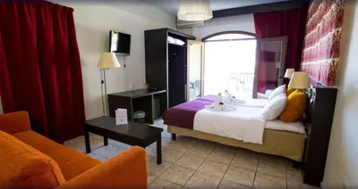 a hotel room with a bed and a chair at Almyrida Village & Waterpark in Almirida