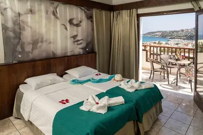 a hotel room with a bed with towels on it at Almyrida Village & Waterpark in Almirida