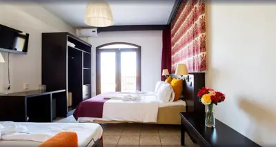 a hotel room with two beds and a television at Almyrida Village & Waterpark in Almirida