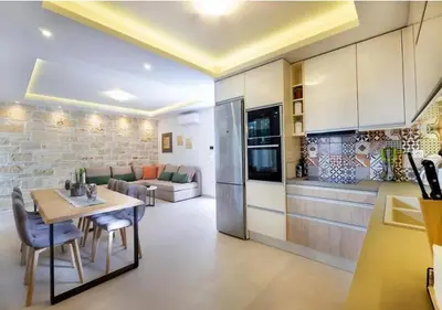 a kitchen and living room with a table and chairs at Southern Paradise Villas - Private Pool in Kalamaki Chanion