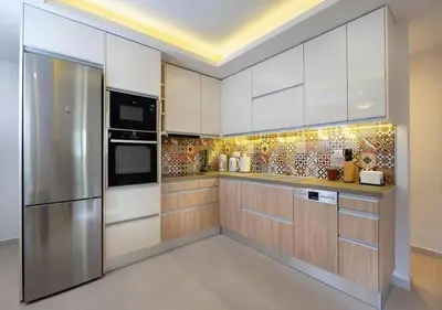 a kitchen with white cabinets and a stainless steel refrigerator at Southern Paradise Villas - Private Pool in Kalamaki Chanion
