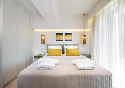 a bedroom with a large bed with two yellow pillows at Southern Paradise Villas - Private Pool in Kalamaki Chanion