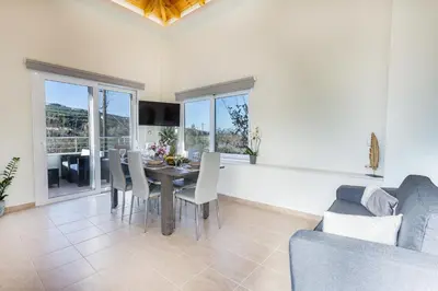a living room with a table and chairs and a couch at Creta Galini House in Sirílion