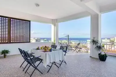 a dining room with a table and chairs and the ocean at Sea City and Mountain View Apartment in Chania Town