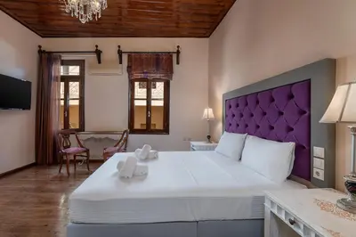a bedroom with a large bed with a purple headboard at Old Town Suites in Chania Town