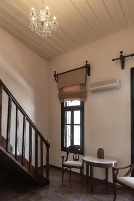 a room with a staircase and a table and a chandelier at Old Town Suites in Chania Town