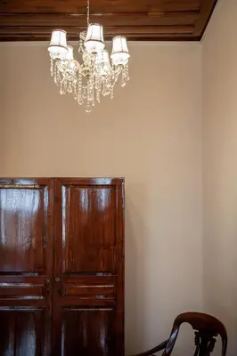 a chandelier hangs above a wooden cabinet in a room at Old Town Suites in Chania Town