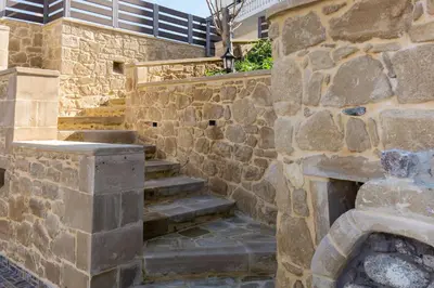a stone wall with stairs in front of a building at Castello Villa - Seaview Villa atop the Venetian Walls in Kissamos