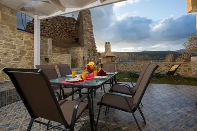 a table and chairs on a patio with a view at Castello Villa - Seaview Villa atop the Venetian Walls in Kissamos