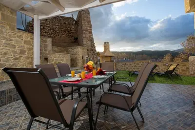 a patio with a table and chairs on a patio at Castello Villa - Seaview Villa atop the Venetian Walls in Kissamos