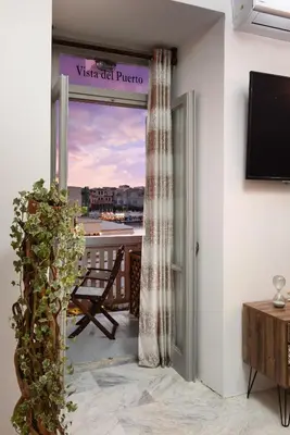 a room with a balcony with a view of a city at Vista del Puerto in Chania Town