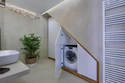 a bathroom with a washer and dryer under a staircase at Koum Kapi Boutique Apartments in Chania Town